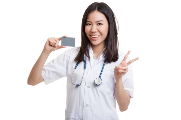 Asiatische junge Ärztin zeigt Siegeszeichen mit Blankokarte. — Stockfoto