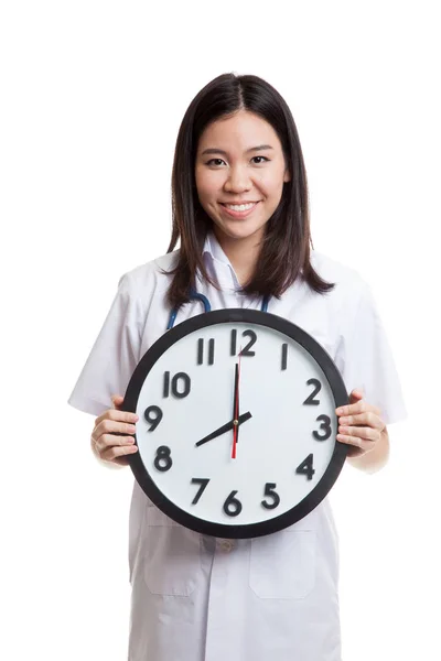 Unga asiatiska kvinnliga läkare håller en klocka. — Stockfoto