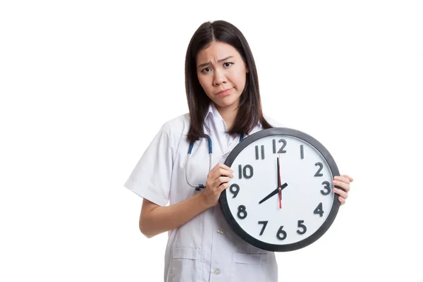 Frustré jeune asiatique femme médecin avec une horloge . — Photo