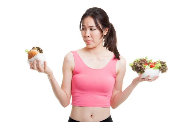 Schöne asiatische gesunde Mädchen mit Salat und Hamburger. — Stockfoto