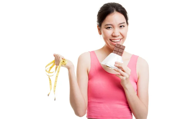 Beautiful Asian healthy girl with chocolate and measuring tape. — Stock Photo, Image