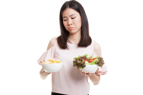 Unga asiatiska affärskvinna med potatischips och sallad. — Stockfoto