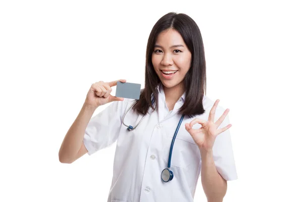 Молодая азиатка-врач показывает знак ОК с пустой карточкой . — стоковое фото