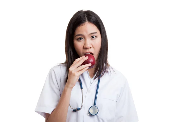 Junge asiatische Ärztin essen Apfel. — Stockfoto