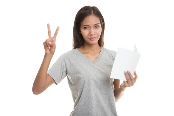 Young Asian woman show victor sign with a book. — Stock Photo, Image