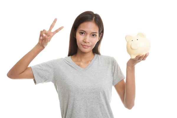 Asyalı kadın göstermek zafer işareti domuz para banka ile. — Stok fotoğraf