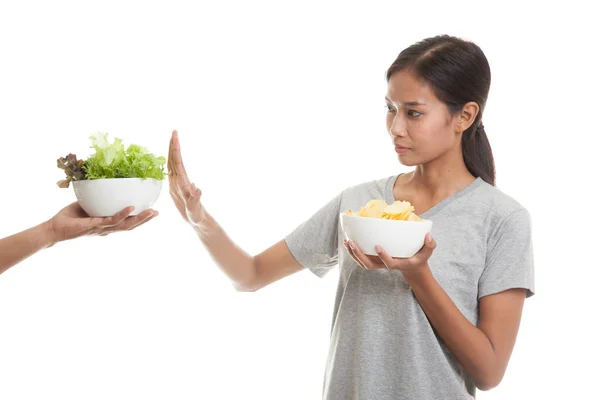 Jonge Aziatische vrouw met aardappel chips nee zeggen tegen salade. — Stockfoto