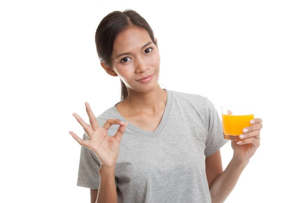 Junge asiatische Frau zeigen ok trinken Orangensaft. — Stockfoto
