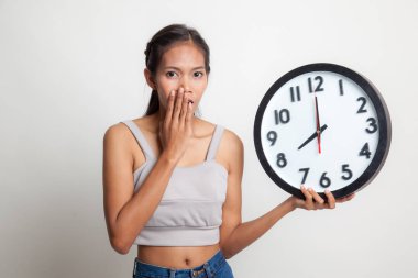 Sabah bir saat ile uykulu genç Asyalı kadın.