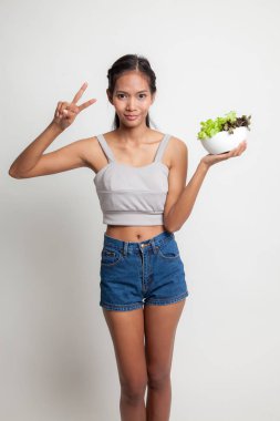 Sağlıklı Asyalı kadın göstermek zafer işareti salata ile.