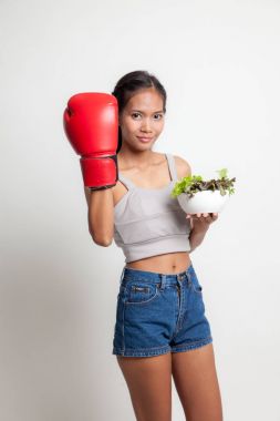 Genç Asyalı kadın boks eldiven ve salata ile.