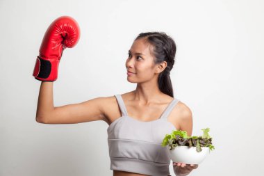 Genç Asyalı kadın boks eldiven ve salata ile.