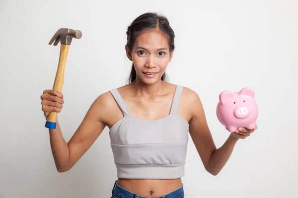 Asiatisk kvinna med gris mynt bank och hammare. — Stockfoto