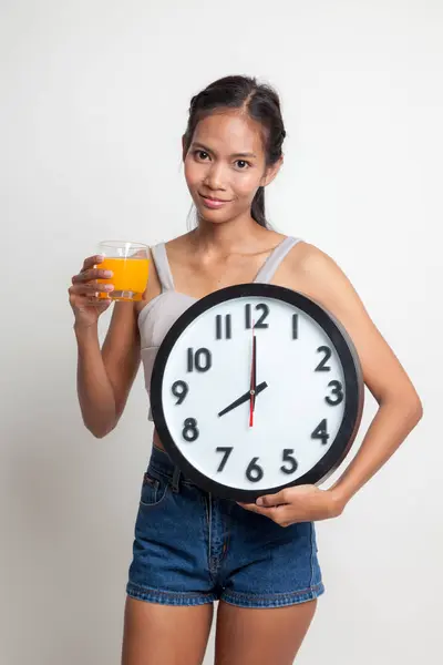 Femme asiatique avec une horloge boisson jus d'orange . — Photo