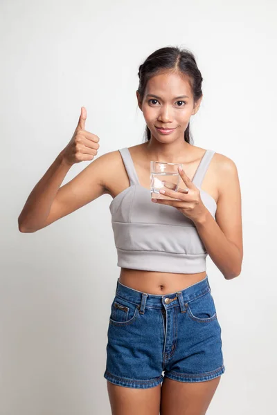 年轻的亚洲女人竖起大拇指与一杯喝水. — 图库照片