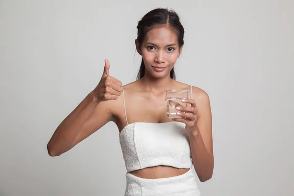 Jovem mulher asiática polegares para cima com um copo de água potável . — Fotografia de Stock