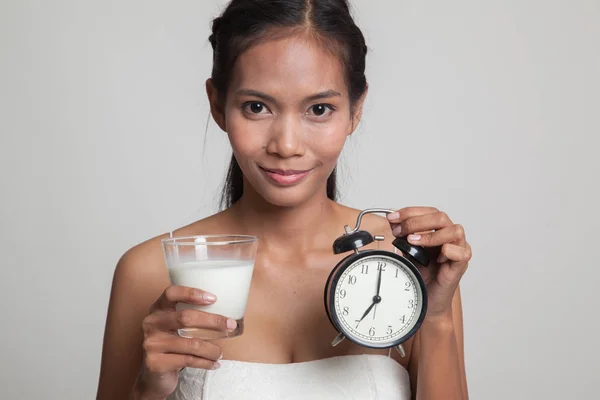 Gesunde asiatische Frau trinkt Glas Milch halten Uhr. — Stockfoto