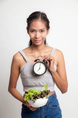 Saat ve salata ile genç Asyalı kadın.