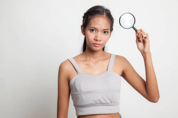 Jovem mulher asiática com uma lupa . — Fotografia de Stock