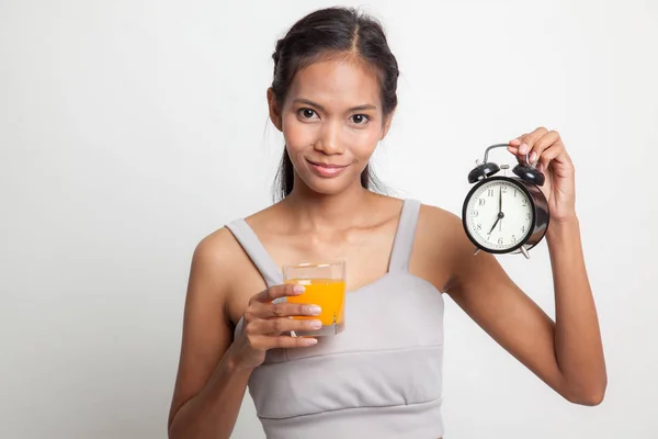 Aziatische vrouw met een klok drankje oranje sap. — Stockfoto