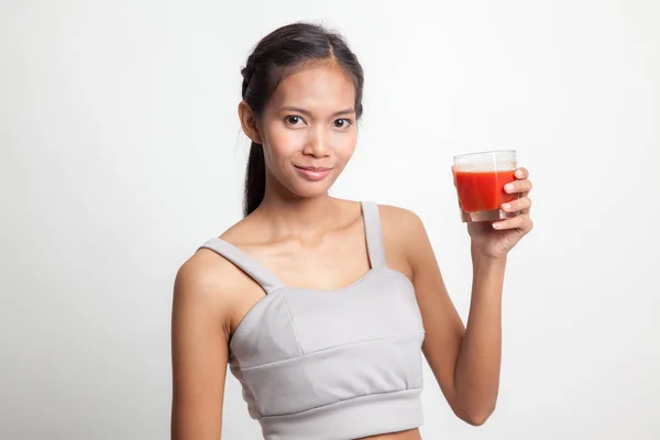Jonge Aziatische vrouw drankje tomatensap. — Stockfoto