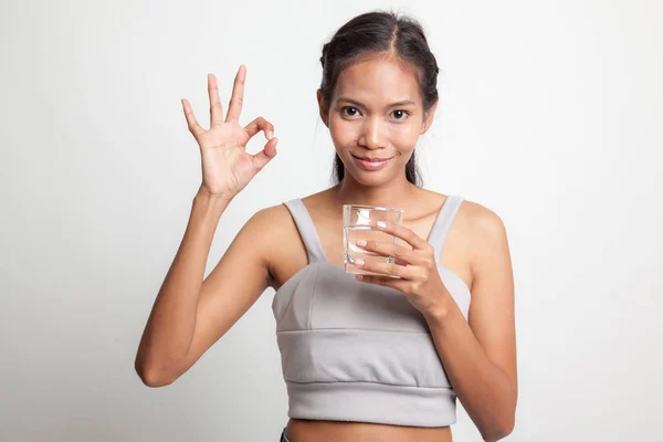 Jonge Aziatische vrouw Toon Ok met een glas drinkwater. — Stockfoto