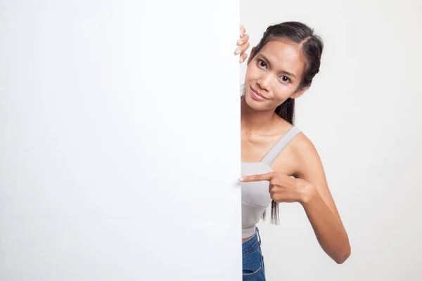 Jonge Aziatische vrouw punt naar een leeg teken. — Stockfoto