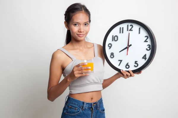 Mujer asiática con un reloj beber jugo de naranja . —  Fotos de Stock