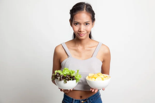 Jovem mulher asiática com batatas fritas e salada . — Fotografia de Stock