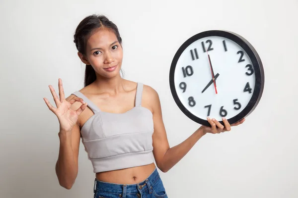 Joven asiática show OK con un reloj . —  Fotos de Stock