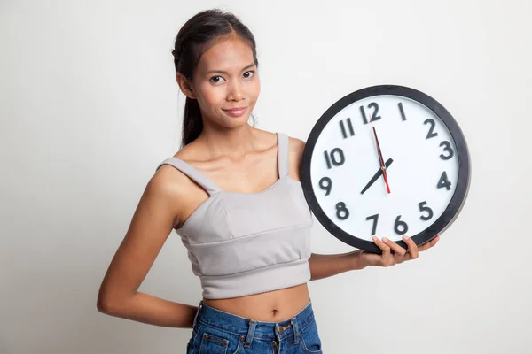 Jeune femme asiatique avec une horloge. — Photo