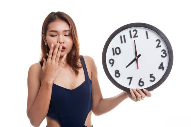 Sabah bir saat ile uykulu genç Asyalı kadın.