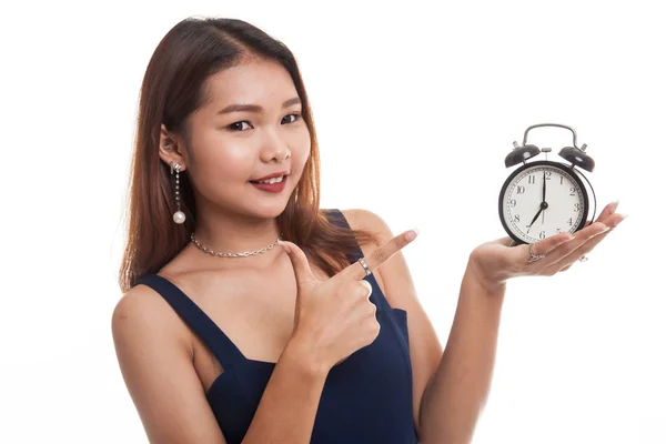 Junge asiatische Frau zeigt auf eine Uhr. — Stockfoto