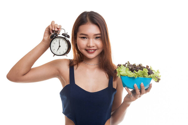 Young Asian woman with clock and salad.