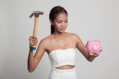 Asyalı kadın domuz para banka ve çekiç ile.