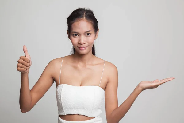 Hermosa joven asiática mostrar la palma de la mano y pulgares hacia arriba . —  Fotos de Stock