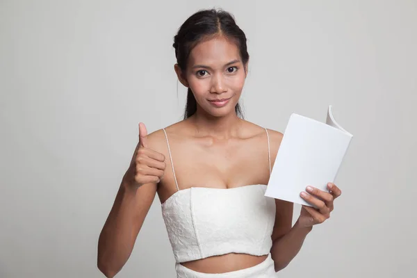 Jeune femme asiatique pouces vers le haut avec un livre . — Photo