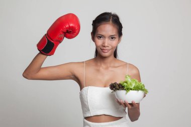 Genç Asyalı kadın boks eldiven ve salata ile.
