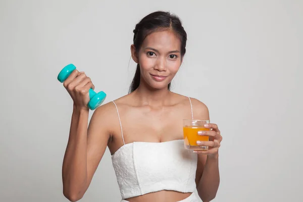 Jonge Aziatische vrouw met halter drankje oranje sap. — Stockfoto