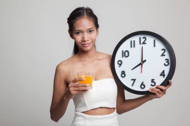 Asyalı kadın saati içki portakal suyu ile.