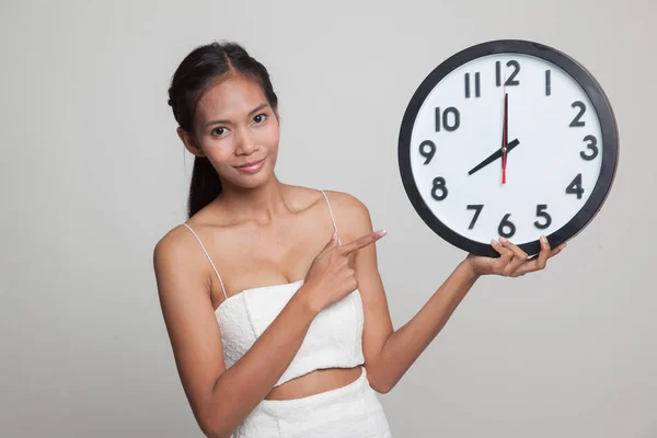 Joven asiática mujer punto a un reloj . —  Fotos de Stock