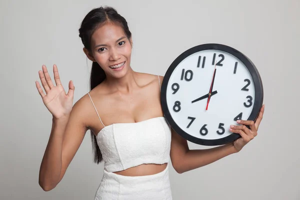 Gelukkig jonge Aziatische vrouw met een klok. — Stockfoto