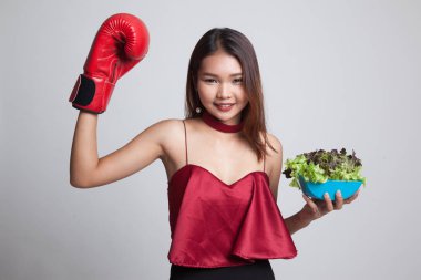Genç Asyalı kadın boks eldiven ve salata ile.