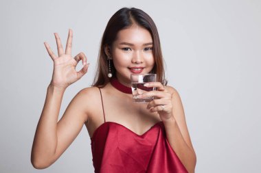 Genç Asyalı kadın göster Ok ile içme suyu bir bardak.