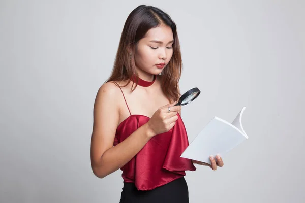 Femme asiatique avec un livre et une loupe . — Photo