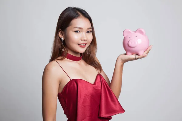 Bir domuz para banka ile genç Asyalı kadın. — Stok fotoğraf