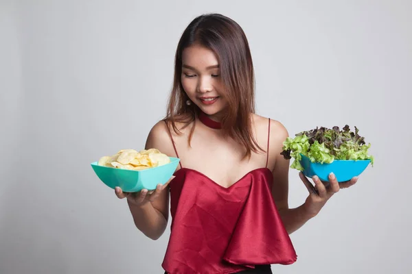 Mujer asiática joven con papas fritas y ensalada . — Foto de Stock