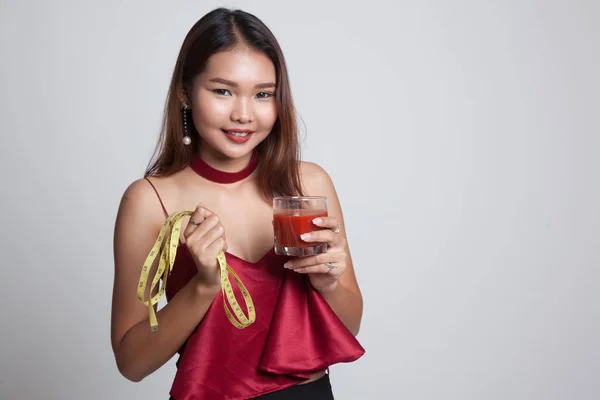 Mujer asiática con jugo de tomate y cinta métrica . —  Fotos de Stock