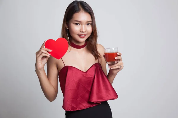 Jonge Aziatische vrouw met tomaten SAP en rood hart. — Stockfoto