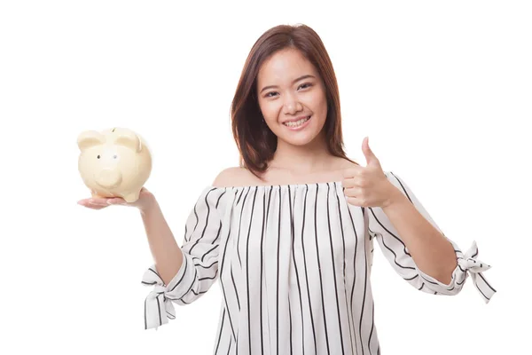 Aziatische vrouw duimen omhoog met varken munt bank. — Stockfoto